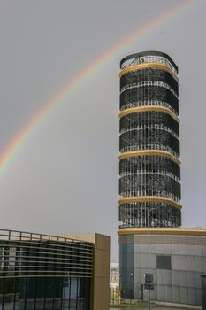 Success in business. Business buildings. concept photo modern architecture. Skyscraper in the form of a tower on the background of a rainbow.