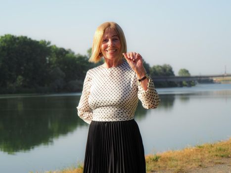 single female pensioner having fun in a park - aging free and wellness concept