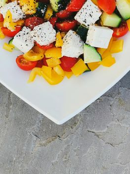 Fresh vegetable greek salad with cherry tomatoes, bell pepper, cucumber, feta cheese, olive oil and seasonal spices, healthy food diet and delicious meal recipe concept