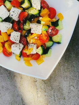 Fresh vegetable greek salad with cherry tomatoes, bell pepper, cucumber, feta cheese, olive oil and seasonal spices, healthy food diet and delicious meal recipe concept