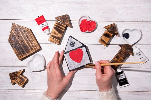 female hands draw a heart on a wooden house, crafting, step by step instructions how to make decor for valentine's or mother's day, Sweet Home. High quality photo