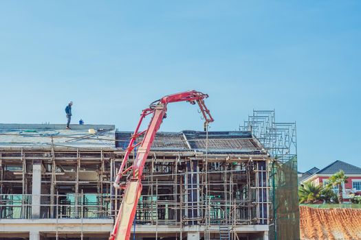 Technical modern telescopic self erection crane. Concrete multi-storey new house residential building construction process using formwork. Industry, real estate, investment, relocation. Close view.