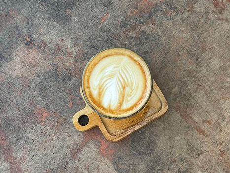 beautiful cup of cappuccino coffee with latte art in the wooden space background