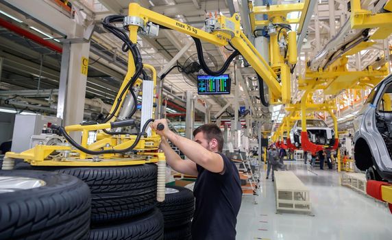 Factory for the production of cars, factory conveyor. Cars are being assembled.