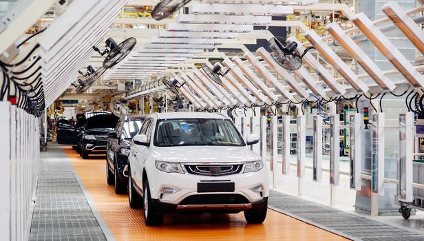 Factory for the production of cars, factory conveyor. Cars are being assembled.