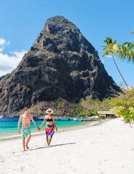 couple walking on the beach during summer vacation on a sunny day, men and woman on vacation at the tropical Island of Saint Lucia Caribbean. Sugar beach St Lucia Caribbean