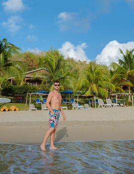 young men in a swim short on vacation in Saint Lucia, luxury holiday Saint Lucia Caribbean, men and woman on vacation at the tropical Island of Saint Lucia Caribbean. Calabash beach St Lucia Caribbean