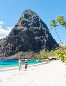 couple walking on the beach during summer vacation on a sunny day, men and woman on vacation at the tropical Island of Saint Lucia Caribbean. Sugar beach St Lucia Caribbean