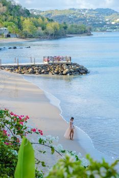 Asian women walking at the beach on vacation in Saint Lucia, luxury holiday Saint Lucia Caribbean, women on vacation at the tropical Island of Saint Lucia Caribbean. Calabash beach St Lucia Caribbean