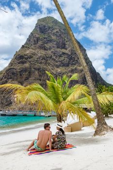 couple sunbathing on the beach during summer vacation on a sunny day, men and woman on vacation at the tropical Island of Saint Lucia Caribbean. Sugar beach St Lucia Caribbean