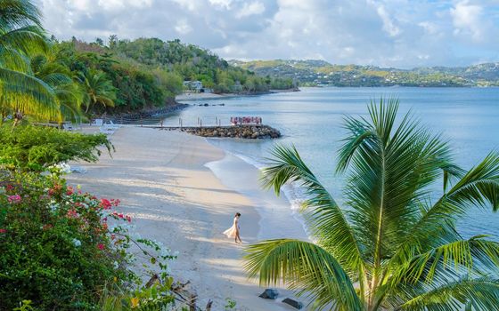 Asian women walking at the beach on vacation in Saint Lucia, luxury holiday Saint Lucia Caribbean, women on vacation at the tropical Island of Saint Lucia Caribbean. Calabash beach St Lucia Caribbean