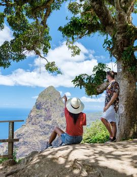 couple hiking in the mountains of Saint Lucia Caribbean, nature trail in the jungle of Saint Lucia with a look at the huge Pitons.