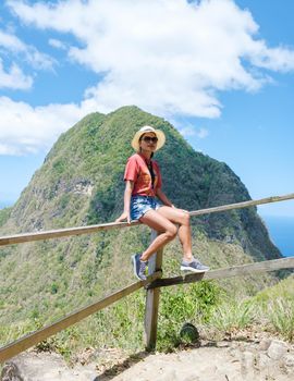 Asian women hiking in the mountains of Saint Lucia Caribbean, nature trail in the jungle of Saint Lucia with a look at the huge Pitons.