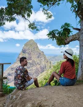couple hiking in the mountains of Saint Lucia Caribbean, nature trail in the jungle of Saint Lucia with a look at the huge Pitons.