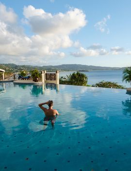 Young men in a swim shorts at Saint Lucia Caribbean, men at infinity pool during sunset. man in a swim short at the pool