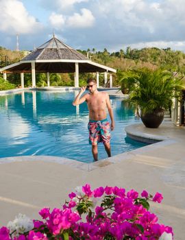 Young men in a swim shorts at Saint Lucia Caribbean, men at infinity pool during sunset. man in a swim short at the pool