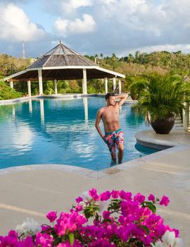 Young men in a swim shorts at Saint Lucia Caribbean, men at infinity pool during sunset. man in a swim short at the pool