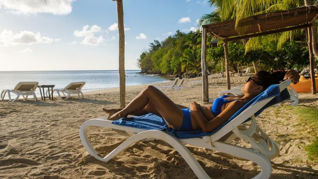 Asian women relaxing on a beach chair during sunset at Saint Lucia Caribbean, Asian women tanning on the beach