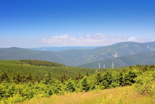 Jeseniky mountains landscape in summer with wind turbines in the background and clear blue sky, Czech Republic.