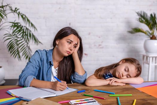 Mother becoming frustrated with daughter whilst doing homework sitting at the table at home in learning difficulties homework. Parenting and education concept