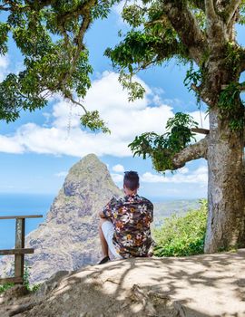 Men hiking in the mountains of Saint Lucia Caribbean, nature trail in the jungle of Saint Lucia with a look at the huge Pitons.