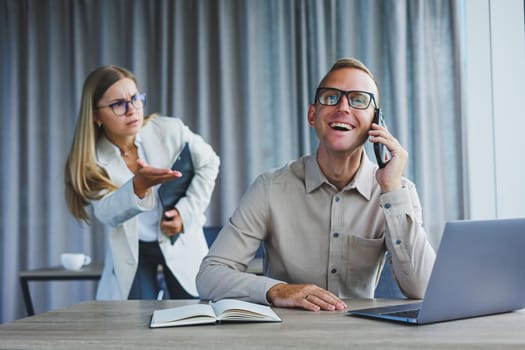 A business woman and a business man are discussing work in the office. Modern office. Colleagues in the office.