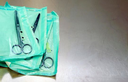 medical scissors on a table with a shallow depth of field in sterile bags.