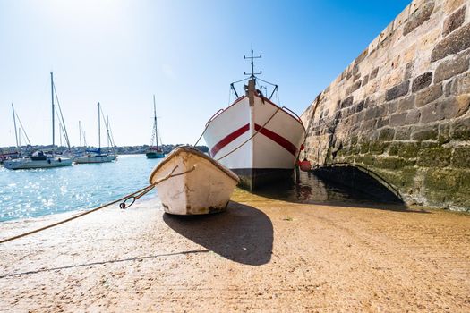 fishing trawler with his tender boat on the hold of the port of Erquy in Brittany