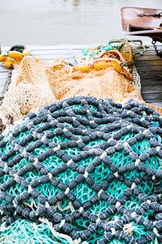 blue fishing net on a pontoon with its ropes and floats covered with morning frost