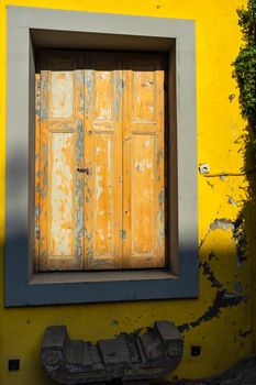 Old abandoned house with bright yellow walls in sunny day in Tbilisi, Georgia