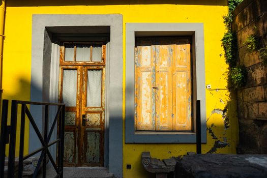 Old abandoned house with bright yellow walls in sunny day in Tbilisi, Georgia