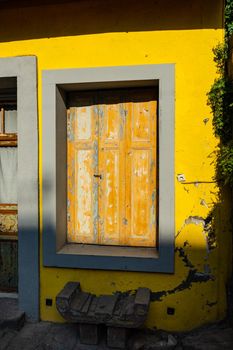 Old abandoned house with bright yellow walls in sunny day in Tbilisi, Georgia