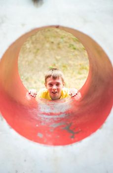 Beautiful boy playing outdoor in the summer park playground