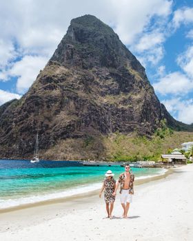 couple walking on the beach during summer vacation on a sunny day, men and woman on vacation at the tropical Island of Saint Lucia Caribbean. Sugar beach St Lucia Caribbean