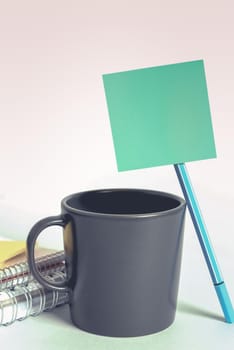 Notebook With Important Message On Desk With Office Supplies.