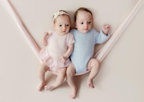Newborn babies twins ooking at camera. Cute infant child kids brother and sister studio photoshoot