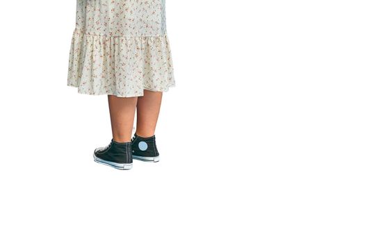 each of the limbs on which a person or animal walks and stands. Chubby female legs in sneakers, print dress in a flower isolated on white