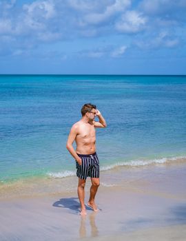 young men in a swim short on vacation in Saint Lucia, luxury holiday Saint Lucia Caribbean, men on vacation at the tropical Island of Saint Lucia Caribbean. Calabash beach St Lucia Caribbean