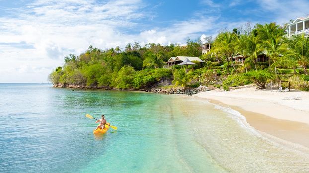 young men in a kayak at a tropical island in the Caribbean sea, St Lucia or Saint Lucia. young man on vacation on a tropical island