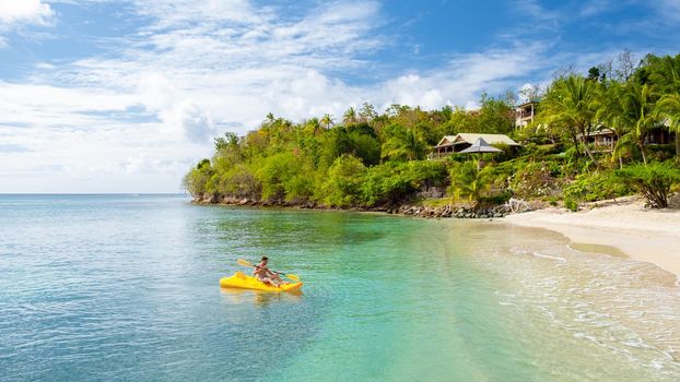 young men in a kayak at a tropical island in the Caribbean sea, St Lucia or Saint Lucia. young man on vacation on a tropical island