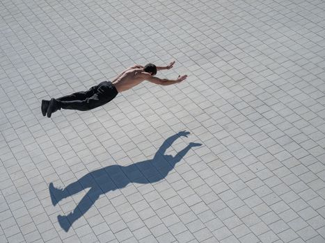 A man doing push-ups with flying outdoors