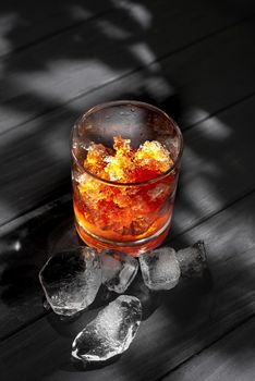 Slushies Whiskey cocktail with ice. on a black background with ice cubes.