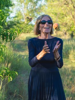 elegant lady picking plums and peaches in a farm during summer