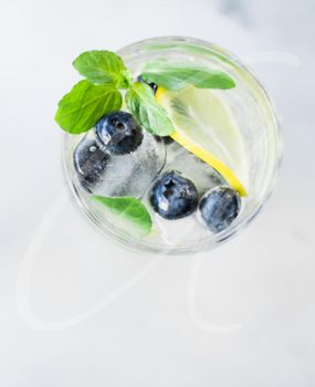drinks, cocktails and celebration styled concept - cocktail with blueberry ice and lemon