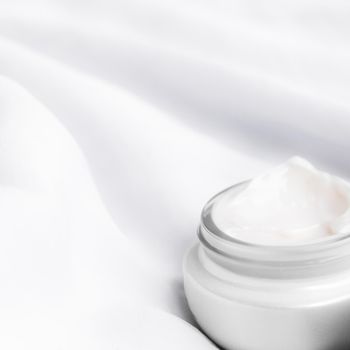 luxury face cream on soft silk - anti-aging, cosmetic and beauty styled concept
