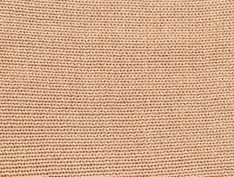 Beige knitted pattern background. Crochet fabric texture.