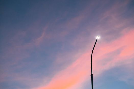 Lamppost at sunset . Sunset time. Copy space. An article about electricity. An article about pillars.