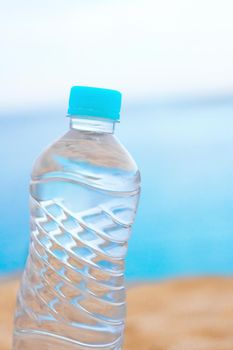 drinks, cocktails and celebration styled concept - bottle of water on the beach