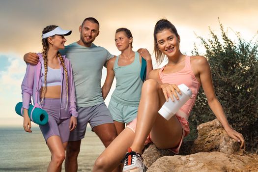 Smiling woman and man fitness team. A happy group of runners rest after running along the sea coast early in the morning