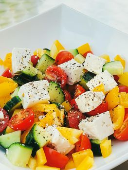 Fresh vegetable greek salad with cherry tomatoes, bell pepper, cucumber, feta cheese, olive oil and seasonal spices, healthy food diet and delicious meal recipe concept